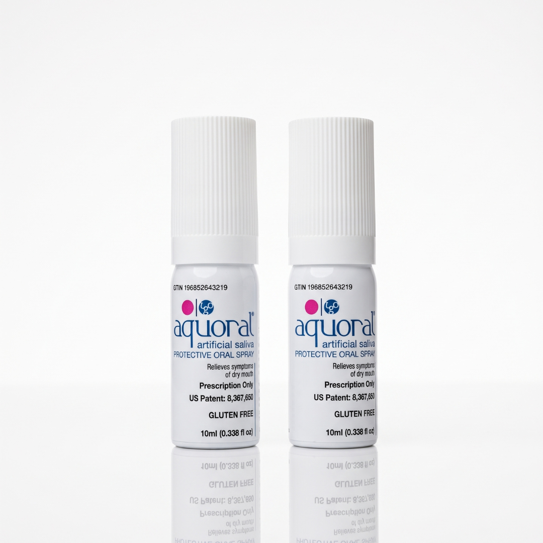 Two small white bottles of aqural artificial saliva protective oral spray standing upright on a white reflective surface.